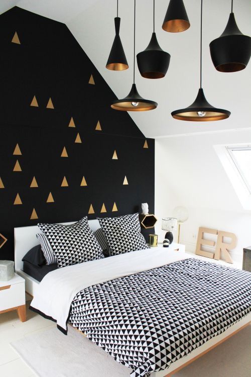 A Scandi space with a mid century modern feel and a black wall with a gold tirangle print