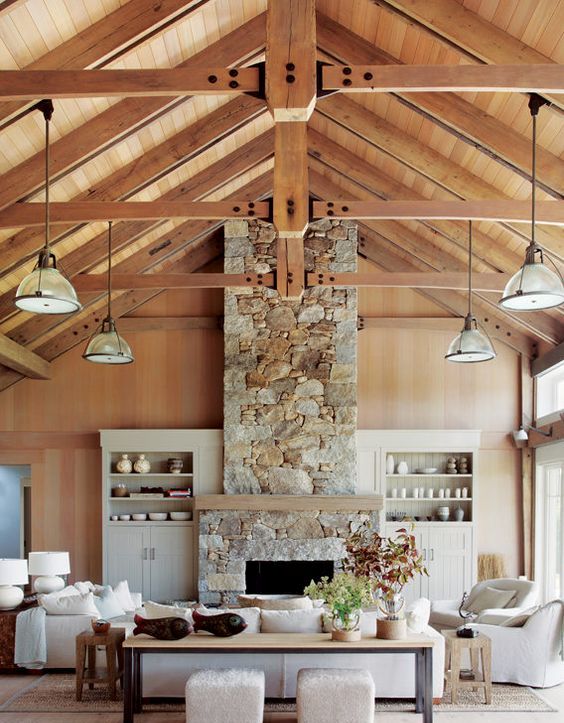 a gorgeous vacation home with a stone clad fireplace and a wooden mantel for a cozy feel