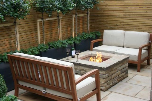 a modern outdoor space with a firepit and a couple of love seats for a romantic dinner