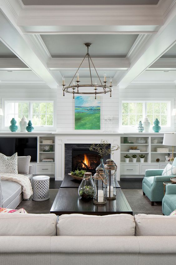 a neutral farmhouse space with a built-in fireplace and some aqua-colored touches