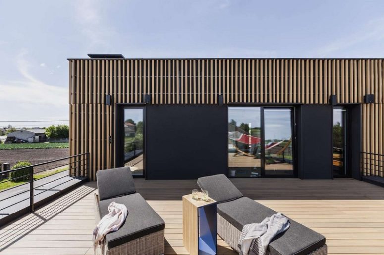 A comfy modern terrace includes two wicker loungers with upholstery