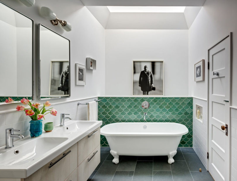 The bathroom is also colorful, with green fish scale tiles and a neutral double vanity