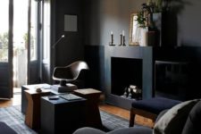 09 a gorgeous elegant dark space with black walls, furniture, a fireplace and a cluster of coffee tables