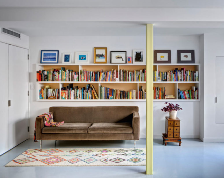 A reading nook is a must for a booklovers' home, there's a velvet sofa and many books
