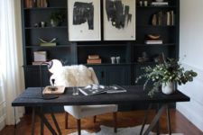 10 a cozy home office with a black shelving unit that takes a whole wall, an amber-colored wooden floor