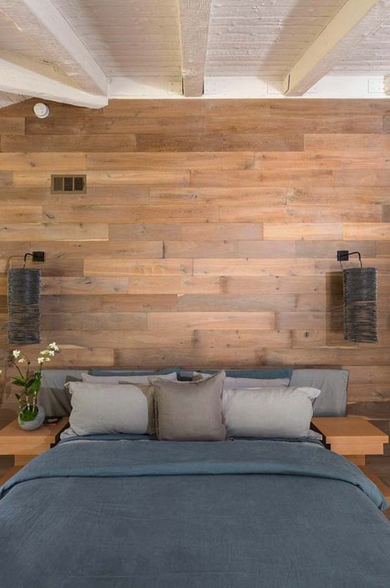 a modern bedroom with a wooden headboard wall and matching nightstands