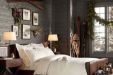 11 a chalet bedroom with a grey wooden wall, anlers and skis for a cozy feel