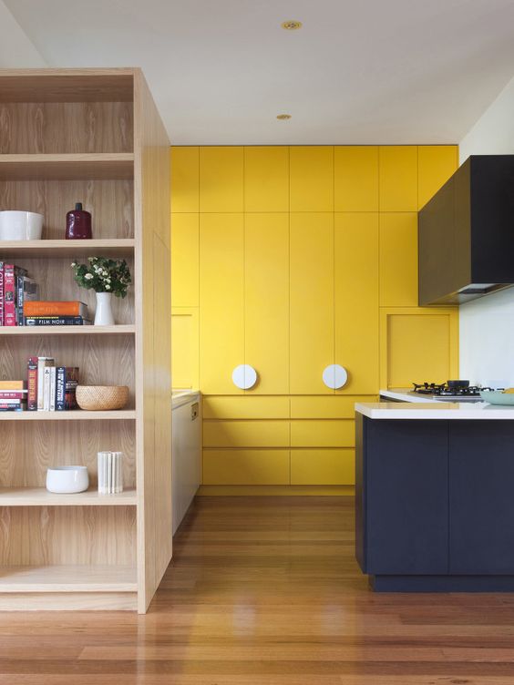 a minimalist bold yellow kitchen, with a navy and white kitchen island for a contrasting touch