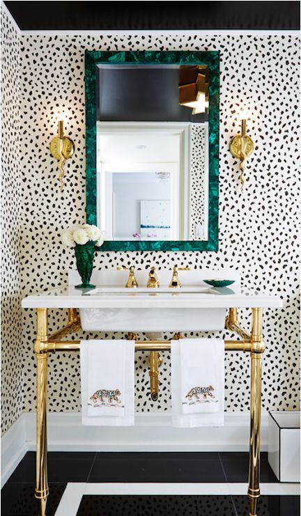 eye-catchy Dalmatian print wallpaper, a malachite mirror frame and brass accents for an eye-catchy look