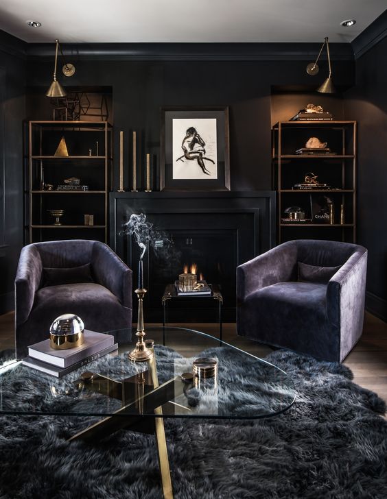 a luxurious dark living room with black walls, purple chairs, a grey faux fur rug and some brass touches for a chic look