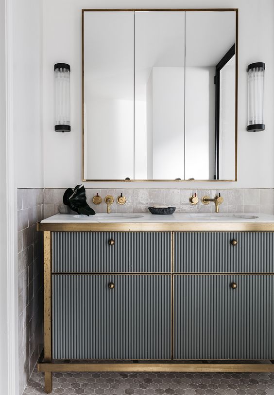a corrugated metal vanity with brass touches looks very bold and interesting, art deco though modern