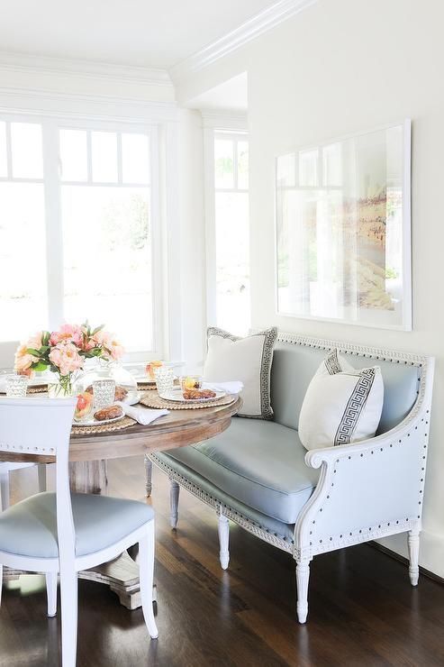 a cut pale blue bench and chairs for a coastal dining space with a rustic wooden table