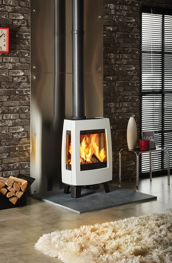 A modern industrial interior is made cozier and more chic with a gorgeous free standing stove with a chic design