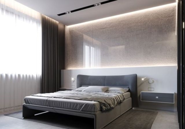 a gorgeous textural light-colored wall with additional lighting and an upholstered grey bed and floating nightstands