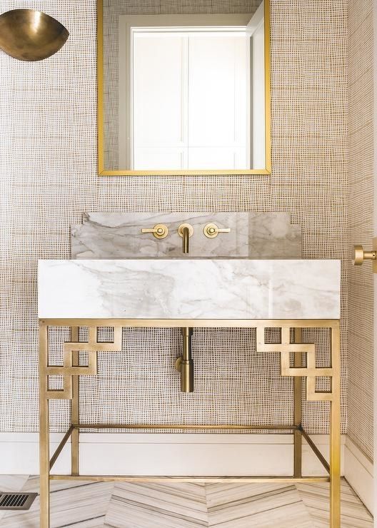 a marble and brass bathroom vanity with geometric decor and fixtures looks gorgeous