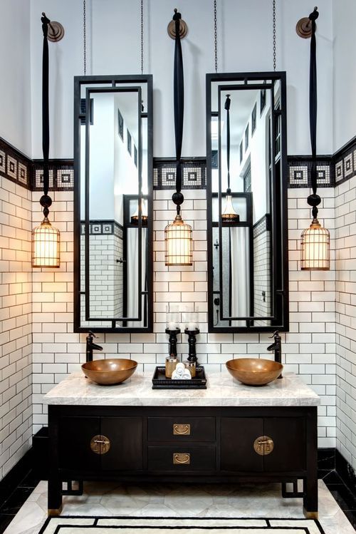 a black double vanity with dark brass touches and a marble counter for a 1920s bathroom