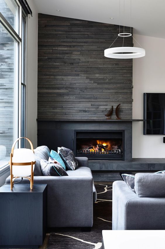 a fireplace clad with grey patterned tiles and reclaimed wood over it to keep it safe