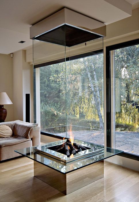 a modern fireplace with clear glass sides to be seen from every part of the house