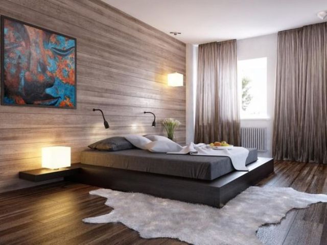 An ultra modern bedroom with a wood clad wall and matching floor, a plaform bed and a faux fur rug