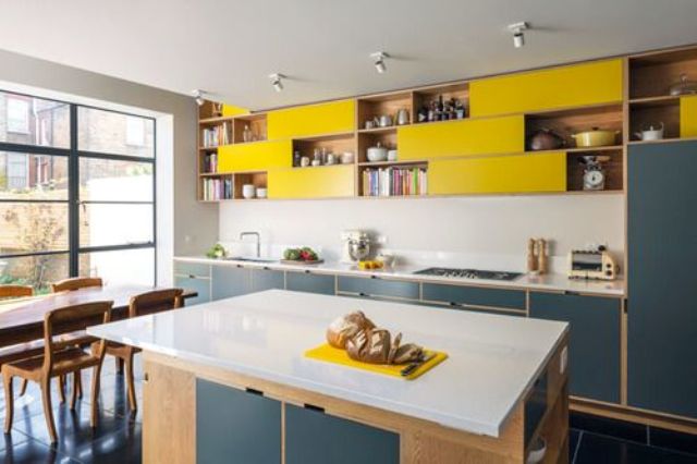 navy and yellow kitchen cabinets with a neutral backsplash and counters look contrasting and chic