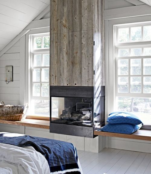 a modern cottage with a fireplace clad with reclaimed wood to add texture to the space