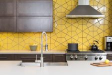 18 a modern dark kitchen with a whole wall taken by yellow tiles looks very bold and unusual