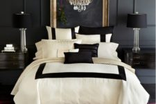 19 an elegant space with a black panel wall, black lamps and nightstands and a glam chandelier