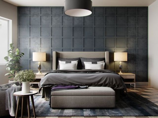 a black panel headboard wall stands out, and a grey upholstered bed with a matching pouf make it cozier