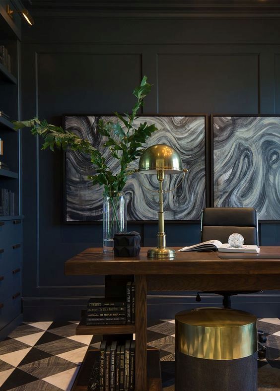 a luxurious home office with black walls, interesting artworks and brass touches for a chic look
