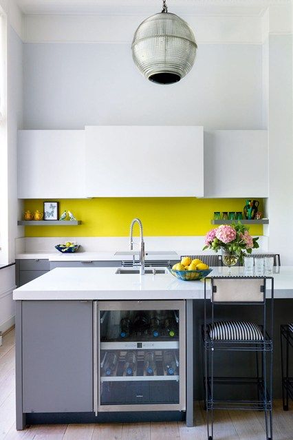 a minimalist kitchen in grey and white and with a neon yellow backsplash for a colorful touch
