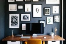 21 a modern home office with black walls, a gallery wall and a comfy desk with a wooden desktop