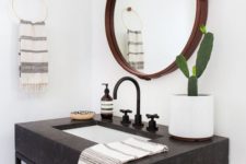 22 a dark stone vanity with black framing and a glass shelf makes the piece look cool