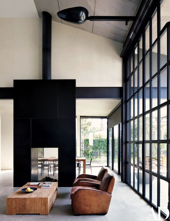 a large double-sided fireplace clad with black tiles steals the show and catches every eye