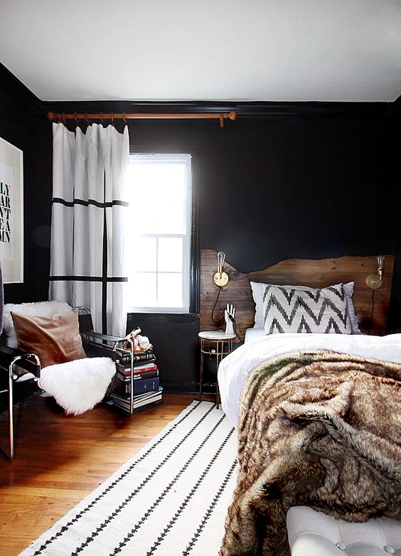 a mid-century modern space with a boho feel, black walls are balanced with whites and natural wood