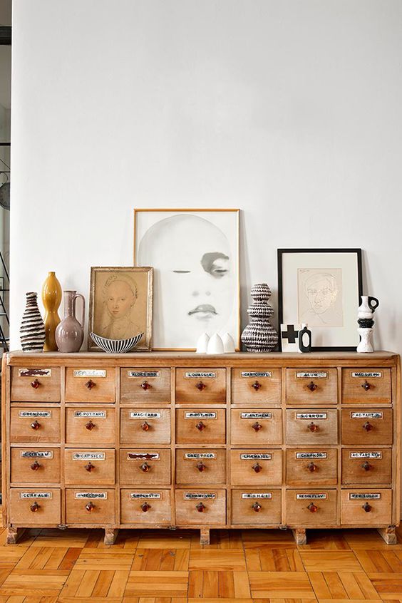 a vintage apothecary cabinet of light-colored wood to make a statement in a living room