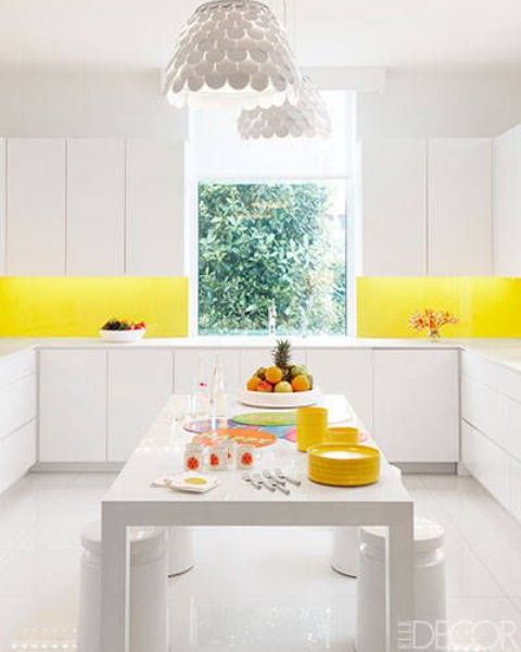 An all white kitchen with a bold yellow backsplash to add a colorful touch and raise your mood
