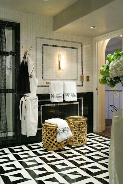 gold geometric stools and brass fixtures and details thoughout the bathroom add a glam feel