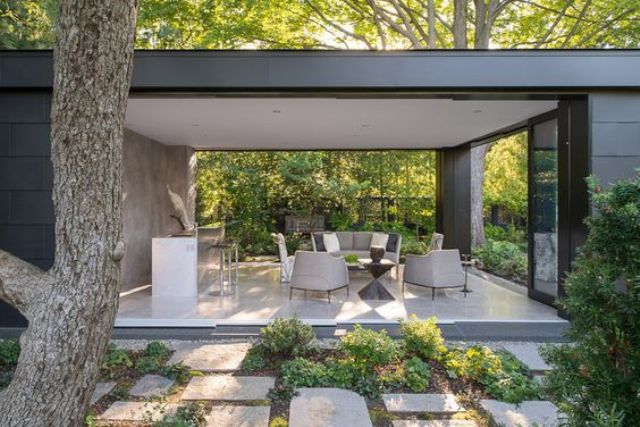 sliding glass doors completely open the living room to outdoors making it an outdoor salon
