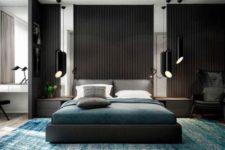 23 a dark space with vertical wooden sltas on the wall, a dark upholstered bed, black hanging lamps and dark linens
