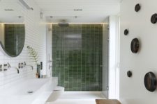 23 a stylish wicker bench and green tiles in the shower creat a natural ambience in the bathroom