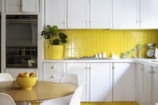 23  a white kitchen is enlivened with a neon yellow tile backsplash, lamps and a planter