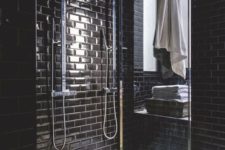 23 glossy black subway tiles with white grout make a cool and bold bathroom