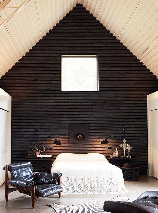 a fantastic cabin bedroom with a black wooden wall for a bold statement in a neutral space