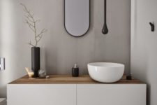 24 a minimalist white vanity with a light-colored wooden top and a bowl sink