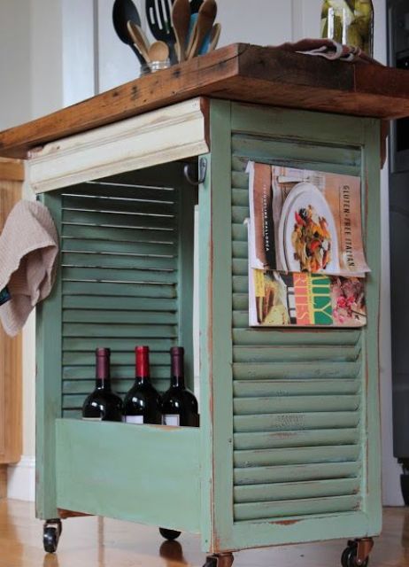 a mobile kitchen island made from shutters, painted mint and with a wooden countertop