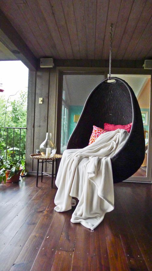 a stylish black egg-shaped hanging chair is a bold idea for a modern porch