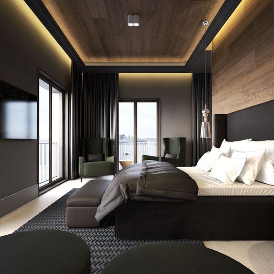 a stylish moody bedroom with light wooden floors and a wooden wall and ceiling, a black upholstered bed and black curtains