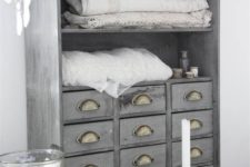 25 an apothecary cabinet painted light grey and renovated into a linen storage item