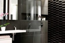 25 large scale black tiles and a textural black tile wall in the shower for a modern look
