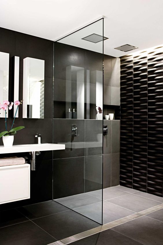 large scale black tiles and a textural black tile wall in the shower for a modern look